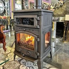 an old fashioned stove in a living room with tile flooring and walls behind it