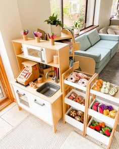 a toy kitchen and living room are shown in this image, with toys on the shelves