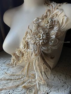 a mannequin with white lace and flowers on it