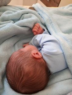 a baby laying on top of a blue blanket