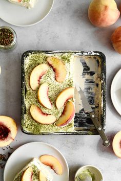 sliced peaches on top of a table with other plates and utensils next to them