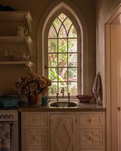 a kitchen with an arched window and sink