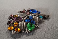 I am offering you this truly exquisite vintage classic spectacular very unique silver tone pin brooch, with multi colored fully faceted prong set rhinestones, in this marvelous dimensional floral design, just look at the marvelous colored rhinestones Very nice all prong set in a fancy scrolled raised relief silver tone setting. What a spectacular combination of colors and elements. It measures a very bold 3 inches, by app. 2 inches. This is such a fine example of a vintage Art Deco style This I Vintage Multicolor Multi-stone Brooch, Vintage Silver Jeweled Brooches, Vintage Multicolor Rhinestones Brooches, Vintage Multicolor Brooch For Party, Multicolor Vintage Brooch For Party, Vintage Multicolor Party Brooch, Silver Multi-stone Brooches, Antique Silver Multi-stone Brooches, Rochester Ny