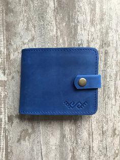 100 % full-grain handmade leather wallet. Bright blue bifold wallet. Precisely made from high quality cow leather. Lasts for years, therefore is a perfect gift. The wallet is engraved with an ancient stylized signs.  Wallets are made from full grain cow leather. Crazy horse is a specially processed leather type that gives it an antique appearance. This type of leather is long lasting, very durable and any scratches or rubs turn it to a different shade, bend line also fades to a different shade. It makes the wallet even better in time. Wallets with their own story! Measures: Dimensions from the outside (closed wallet): 10 cm X 12.5 cm (3.94 in X 4.92 in). Perfectly fits in a back pants pocket.  Dimensions from the inside (opened wallet): 9.5 cm X 23.5 cm (3.74 in X 9.25 in).  Perfectly fits Blue Leather Trifold Wallet With Card Slots, Blue Leather Wallet With Rfid Blocking, Blue Trifold Wallet With Coin Pocket, Everyday Blue Trifold Wallet With Coin Pocket, Handmade Blue Leather Wallet, Blue Trifold Wallet With Card Slots As Gift, Handmade Blue Wallet For Everyday Use, Blue Bifold Wallet For Everyday Use, Blue Wallet With Coin Pocket As Gift