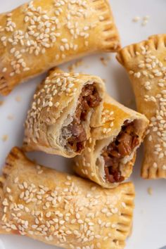 several pastries on a white plate with sesame seeds