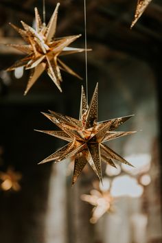 three golden stars hanging from strings in a room