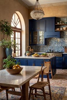 a kitchen with blue cabinets and an island in front of the stove top is surrounded by potted plants