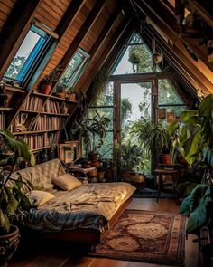 an attic bedroom with lots of plants and bookshelves