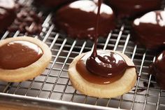 chocolate covered cookies on a cooling rack with one being drizzled over the top