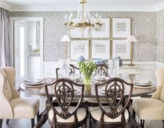 a dining room table with chairs and a chandelier hanging from the ceiling above it