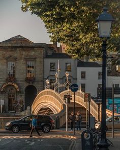 a person crossing a street in front of a building with a wooden bridge over it