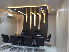 a conference room with black chairs and lights on the ceiling, along with white marble flooring