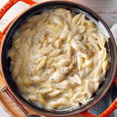 a pot filled with pasta on top of a wooden table