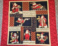 a quilted wall hanging with pictures of santa claus