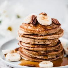 a stack of pancakes topped with bananas and syrup