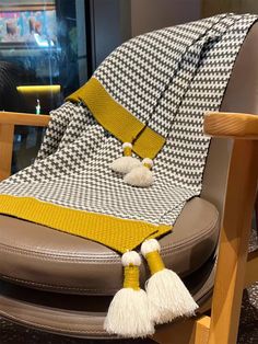 a chair with a blanket and tassels on it