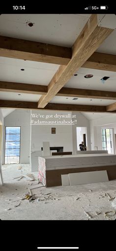 an unfinished room with wood beams and white walls