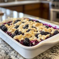 a casserole dish with blueberries and crumbled toppings on top