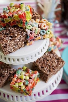 several pieces of cake are stacked on top of each other with colorful cereal toppings