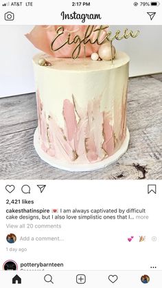 a pink and white cake with gold lettering on top