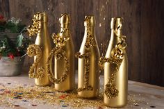 gold glittered wine bottles sitting on top of a wooden table