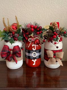 three mason jars decorated with christmas decorations