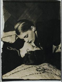 an old black and white photo of a woman laying on a bed with her cat