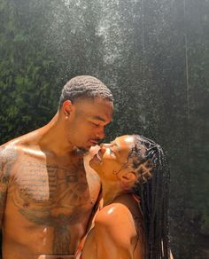 a man and woman standing in the shower with their faces close to each other as they kiss