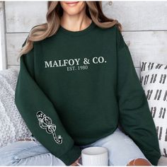 Get ready to be OBSESSED with your Malfoy sweatshirt. It's the cutest and most trendy way to emit all those magical vibes! This is THE CUTEST dark markl sweatshirt! Great as a potterhead gift! * Q U I C K * F A C T S * ✺ 100% preshrunk cotton ✺ Wash and dry normally (on cool for best results) * S I Z I N G * ✺ Models are wearing size XL for an oversized look ✺ Sizing is unisex so runs like men's, though not overly large ✺ Most women find their typical size works best, since they are meant to fit Slytherin Clothes, Harry Potter Sweater, Upcycle Books, Green House, Green Sweater, Girls Trip, Wizard, Sweat Shirt, Adult Outfits