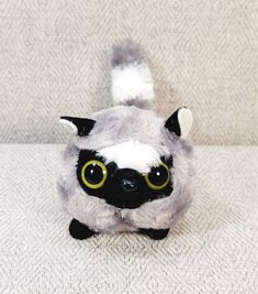 a stuffed animal with big eyes sitting on a couch