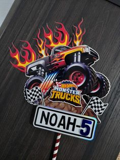 a street sign with an image of a monster truck on it and flames in the background