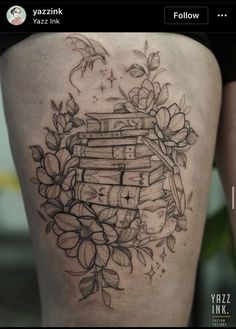 a woman's thigh with books and flowers on it