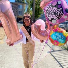 a woman is holding up some balloons