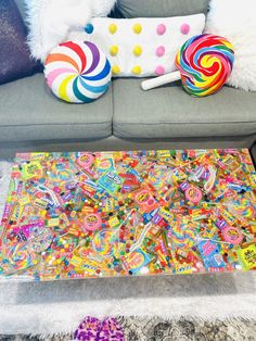 a colorful table with lollipops on it in front of a gray couch