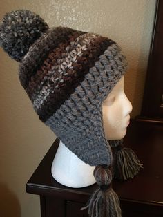 a knitted hat with tassels on top of a mannequin head