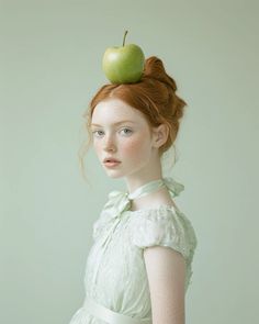 a woman with red hair wearing a green dress and an apple on top of her head