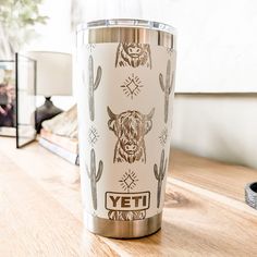 a stainless steel yeti tumbler sitting on top of a wooden table next to a mirror