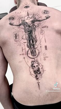 a man with a tattoo on his back is looking down at the crucifix