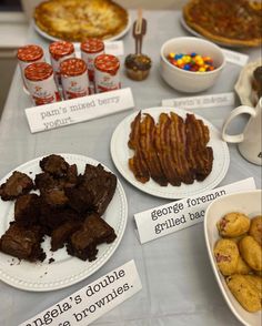 a table topped with plates and bowls filled with desserts next to cupcakes