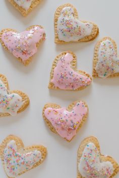 some heart shaped cookies with sprinkles on them are arranged in the shape of hearts