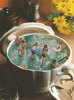 there are many people in the water in this large pot that is on the table