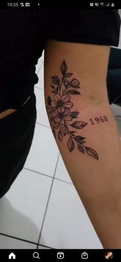 a woman's leg with a flower tattoo on her left arm and the number 1950 written in black ink