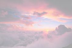 the sky is filled with clouds and pink hues as the sun sets in the distance