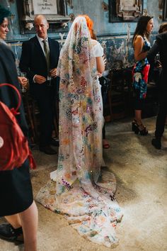 a woman in a wedding dress standing next to other people