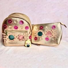 two gold purses with pink flowers on them