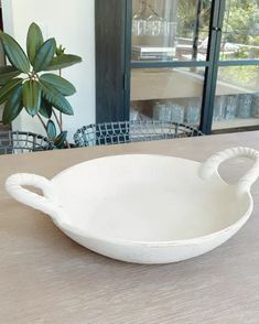 a white bowl sitting on top of a wooden table