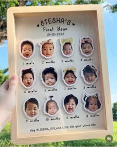 a person holding up a wooden frame with pictures of babys in different faces on it