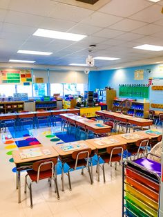 an empty classroom filled with lots of desks and colorful books on the tables in front of them