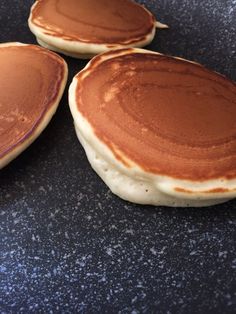 three pancakes sitting on top of a black counter