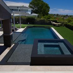 an outdoor swimming pool surrounded by grass